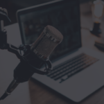 How To Start A Podcast: modern podcast studio setup featuring a microphone, headphones, and a laptop, surrounded by soundproofing panels.