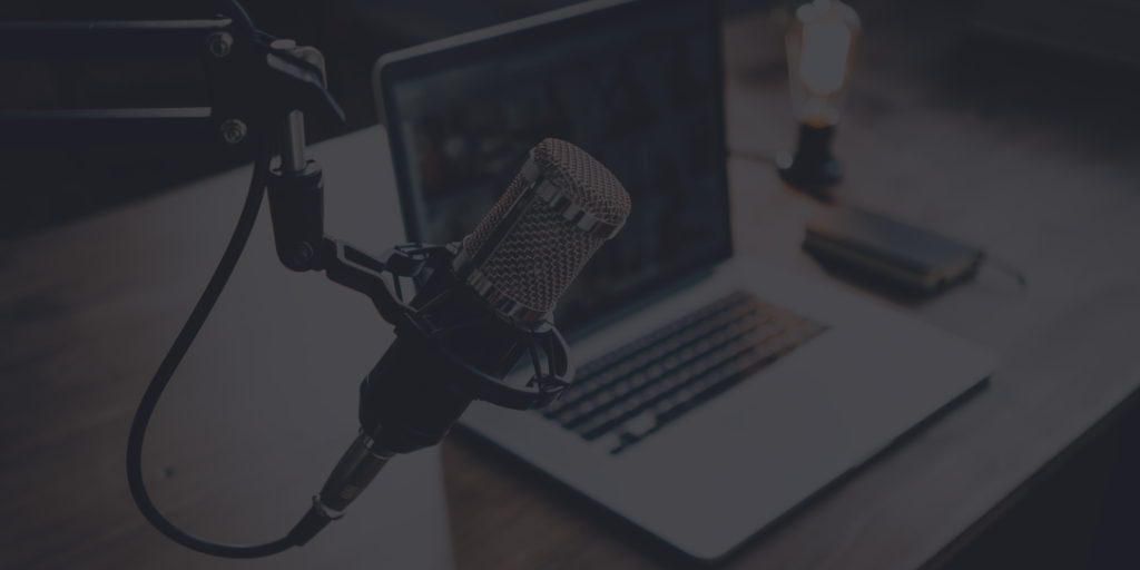 How To Start A Podcast: modern podcast studio setup featuring a microphone, headphones, and a laptop, surrounded by soundproofing panels.